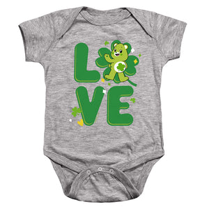 AN OFFCIALLY LICENSED CARE BEARS: UNLOCK THE MAGIC GOOD LUCK BEAR LOVE ST. PATRICK'S DAY BABY BODYSUIT ATHLETIC HEATHER