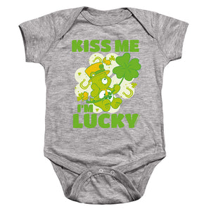 AN OFFCIALLY LICENSED CARE BEARS KISS ME I'M LUCKY ST. PATRICK'S DAY GOOD LUCK BEAR BABY BODYSUIT ATHLETIC HEATHER